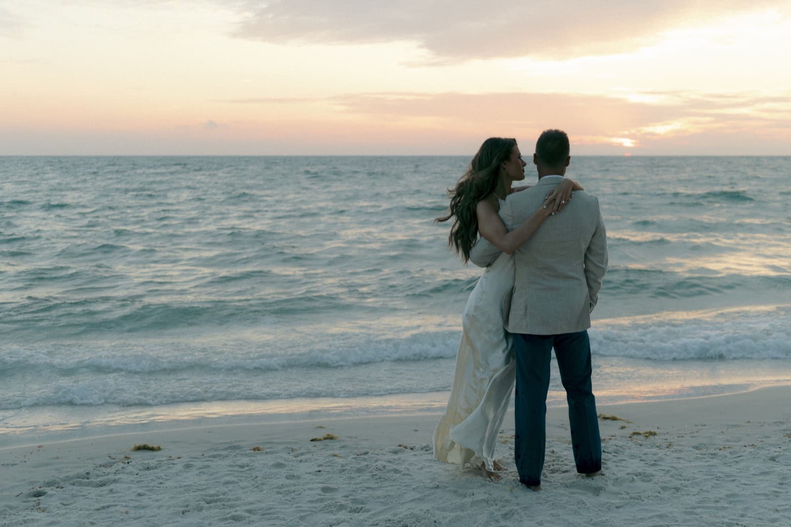 Stephanie and Andy embracing at sunset on the beach